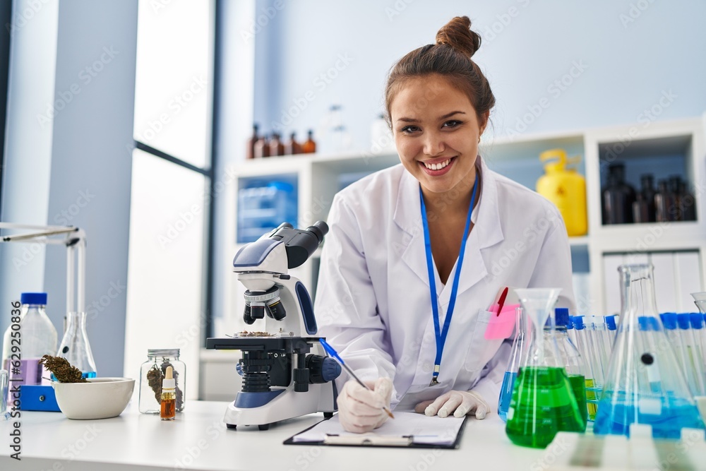 Young beautiful hispanic woman scientist smiling confident writing report working at laboratory Young beautiful hispanic woman scientist smiling confident writing report working at laboratory