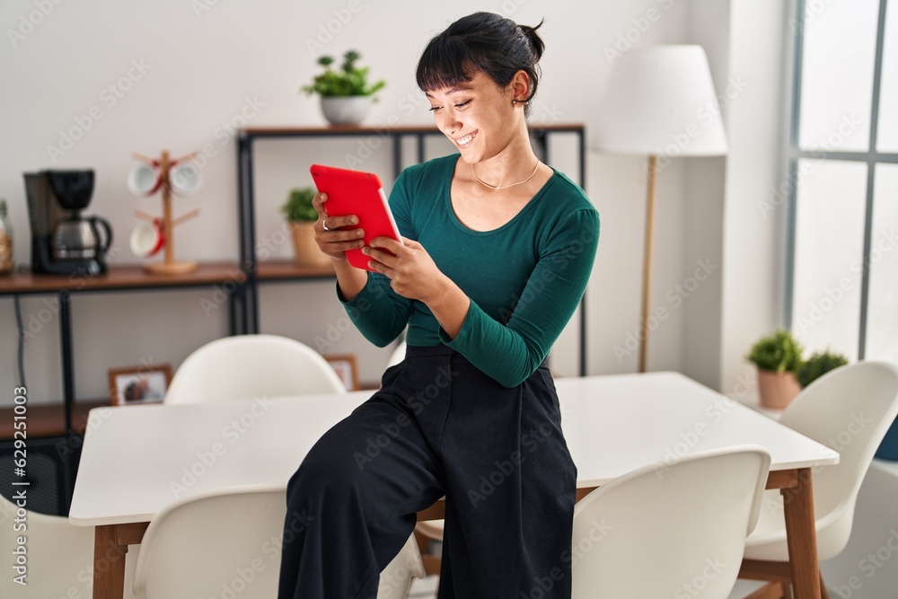Young beautiful hispanic woman smiling confident using touchpad at home Young beautiful hispanic woman smiling confident using touchpad at home