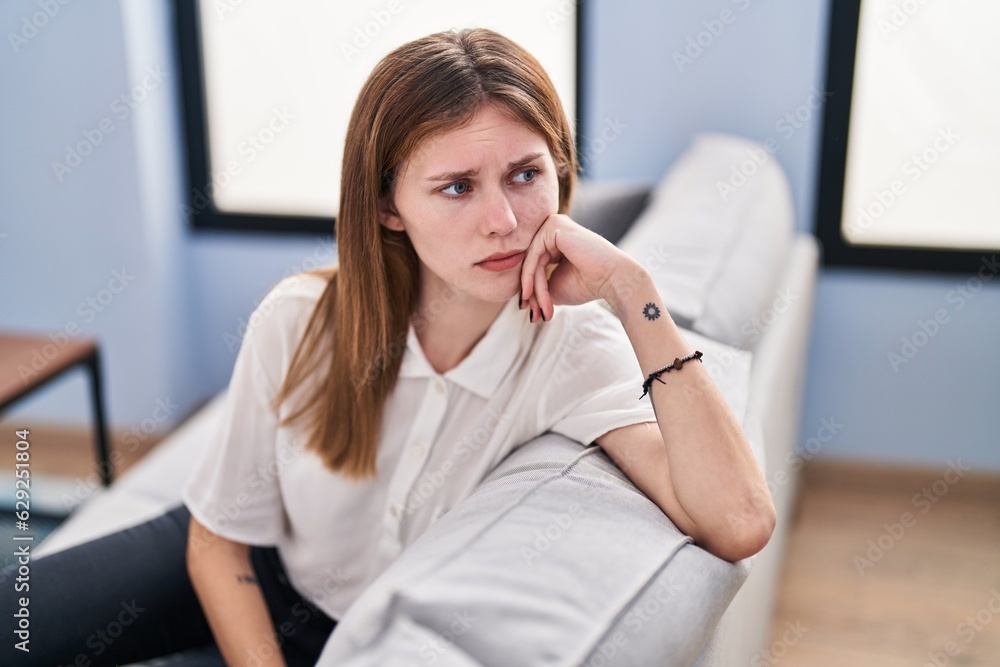 Young blonde woman stressed sitting on sofa at home Young blonde woman stressed sitting on sofa at home