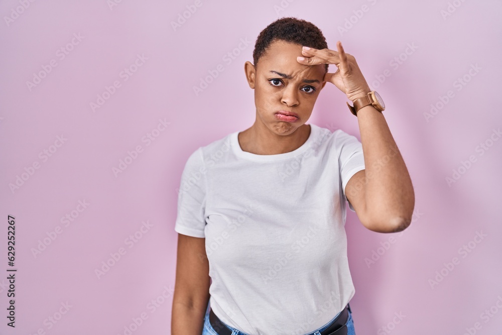 Beautiful african american woman standing over pink background worried and stressed about a problem with hand on forehead, nervous and anxious for crisis Beautiful african american woman standing over pink background worried and stressed about a problem with hand on forehead, nervous and anxious for crisis