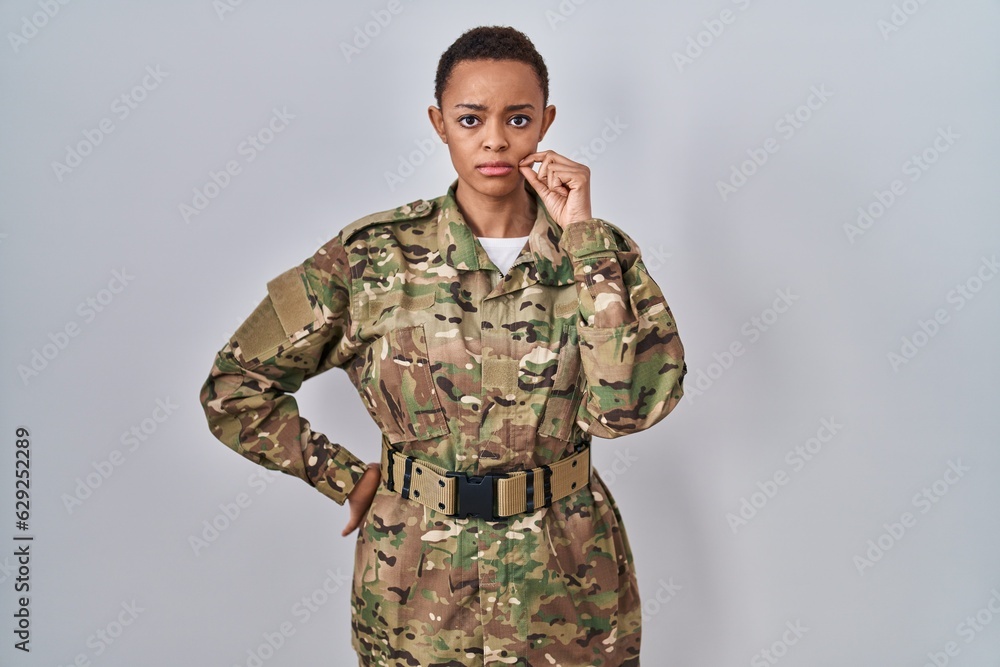 Beautiful african american woman wearing camouflage army uniform mouth and lips shut as zip with fingers. secret and silent, taboo talking Beautiful african american woman wearing camouflage army uniform mouth and lips shut as zip with fingers. secret and silent, taboo talking
