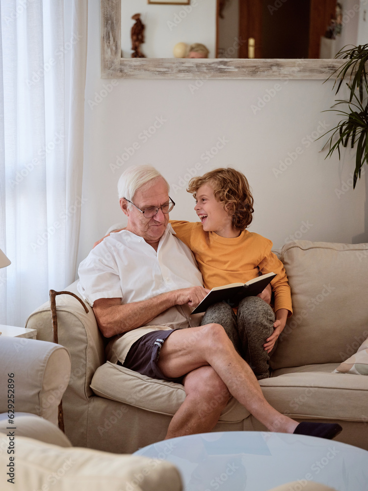 Positive boy reading book with grandfather Positive boy reading book with grandfather