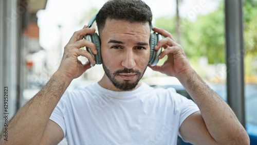 Young arab man listening to music at street