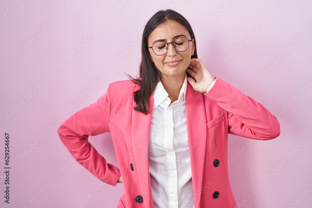 Young hispanic woman wearing business clothes and glasses suffering of neck ache injury, touching neck with hand, muscular pain Young hispanic woman wearing business clothes and glasses suffering of neck ache injury, touching neck with hand, muscular pain