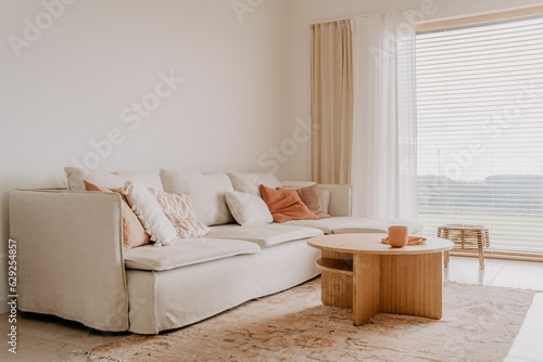 Modern white sofa with a selection of pastel colored pillows in a cozy small living room photo