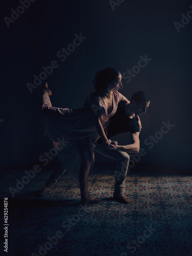 Ballet dancers performing dance in dark studio