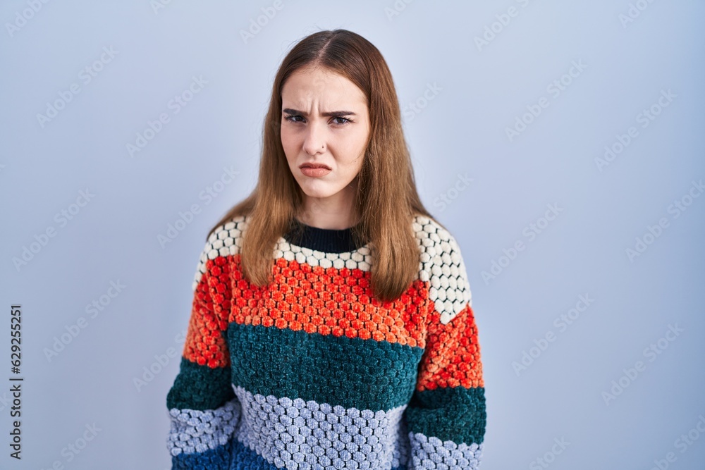 Young hispanic girl standing over blue background skeptic and nervous, frowning upset because of problem. negative person. Young hispanic girl standing over blue background skeptic and nervous, frowning upset because of problem. negative person.