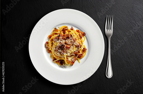 Top view of Plate with spaghetti carbonara on black stone