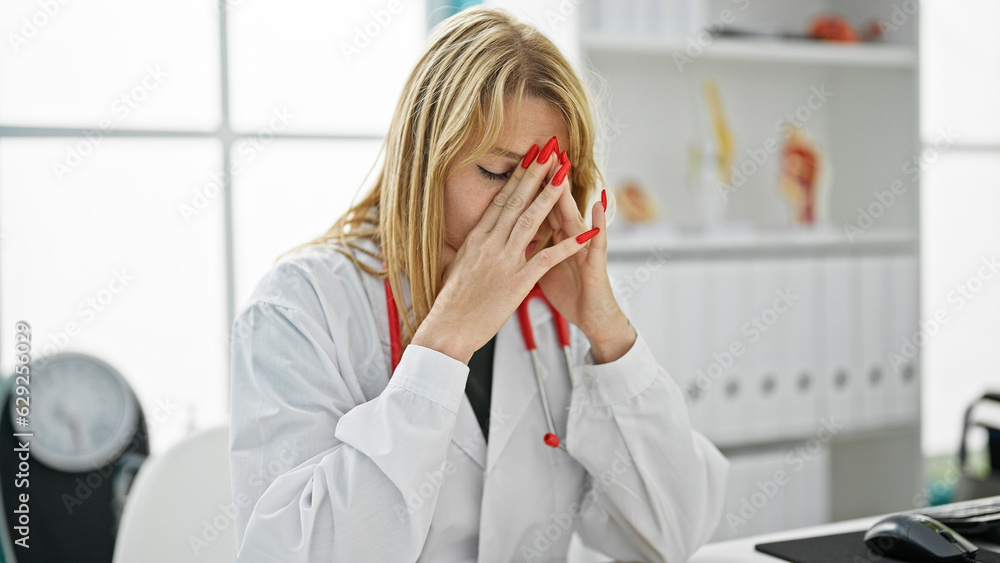 Young blonde woman doctor stressed working at clinic Young blonde woman doctor stressed working at clinic