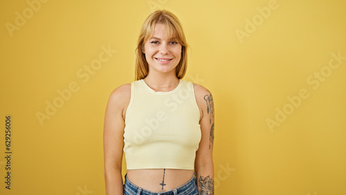 Young blonde woman smiling confident standing over isolated yellow background © Krakenimages.com