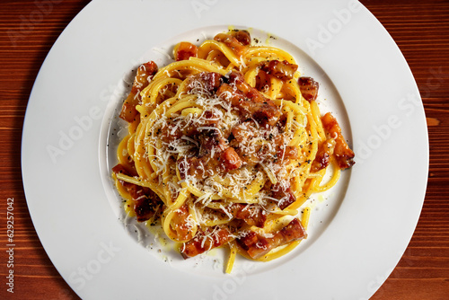 Top view of plate with spaghetti carbonara and grated cheese