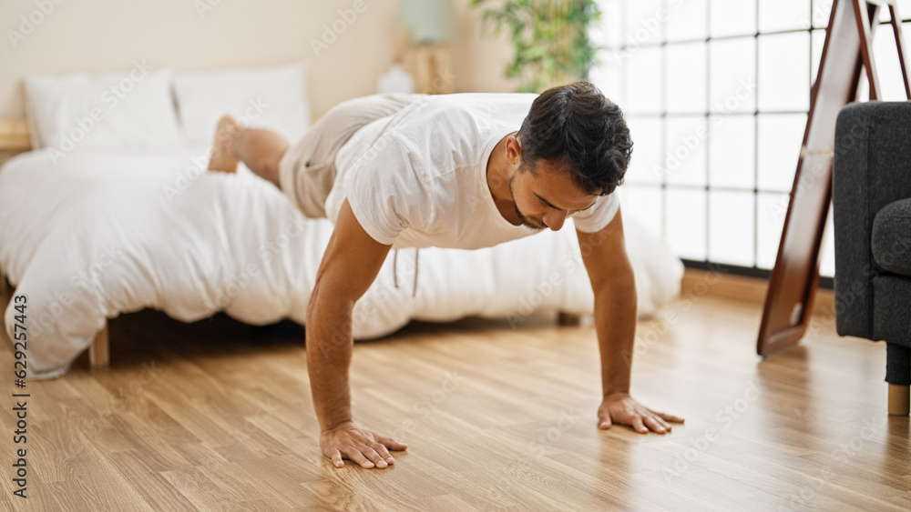 Young hispanic man training push up at bedroom Young hispanic man training push up at bedroom