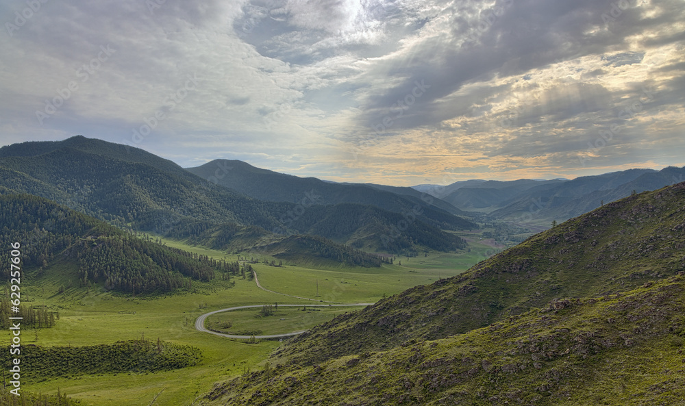 sunlight in Altai mountains under grey clouds