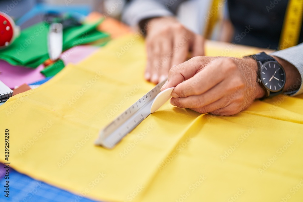 Young blond man tailor make mark on cloth at clothing factory Young blond man tailor make mark on cloth at clothing factory
