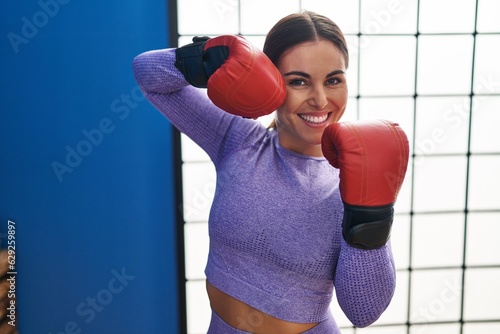 Young beautiful hispanic woman smiling confident boxing at sport center