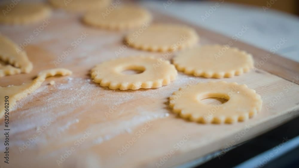 Woman hand putting shortbread dough on a wooden board. Woman hand putting shortbread dough on a wooden board.