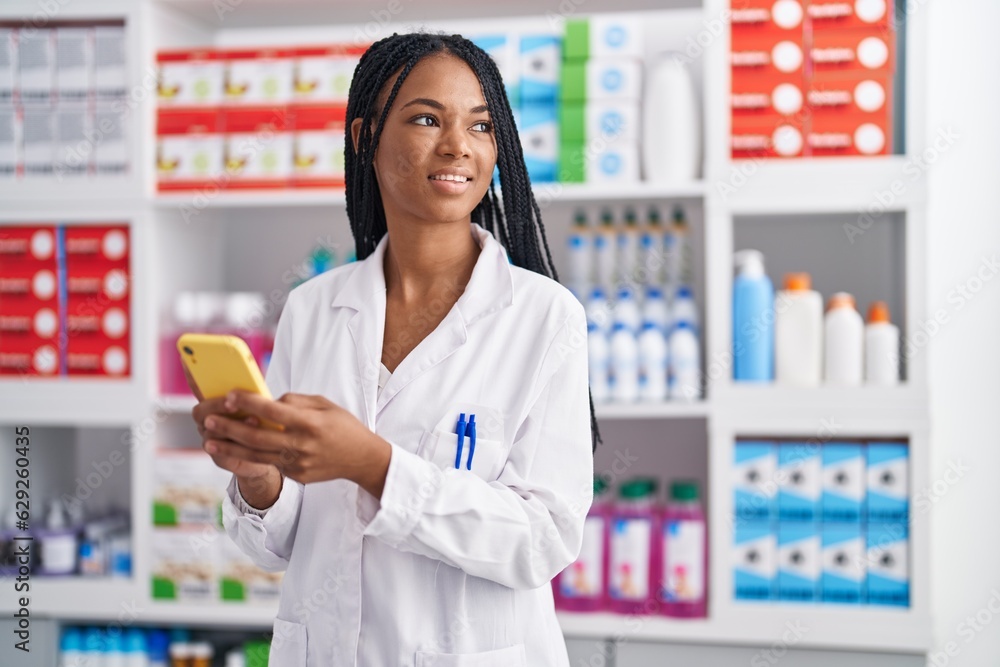 African american woman pharmacist smiling confident using smartphone at pharmacy African american woman pharmacist smiling confident using smartphone at pharmacy