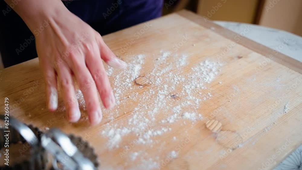 Dusting a wooden work surface with flour Dusting a wooden work surface with flour