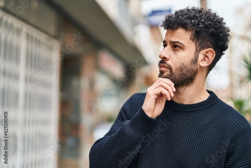 Young arab man standing with doubt expression at street