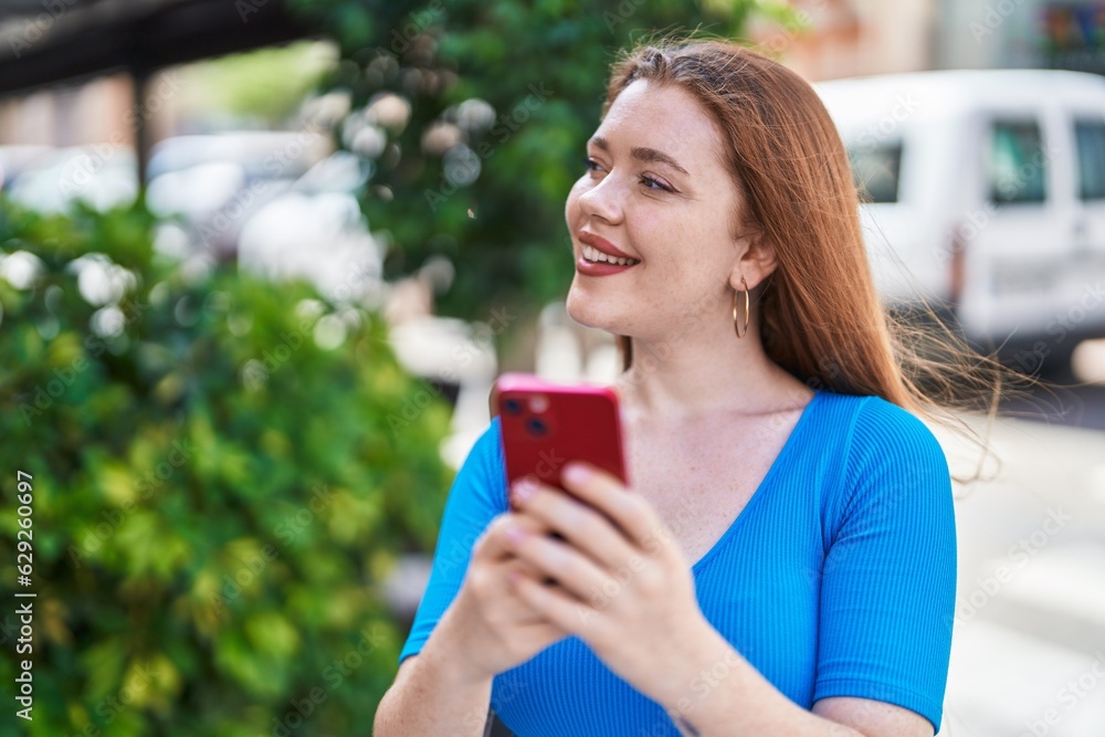 Young redhead woman smiling confident using smartphone at street Young redhead woman smiling confident using smartphone at street
