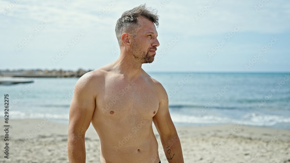 Young man tourist standing with relaxed expression at the beach Young man tourist standing with relaxed expression at the beach