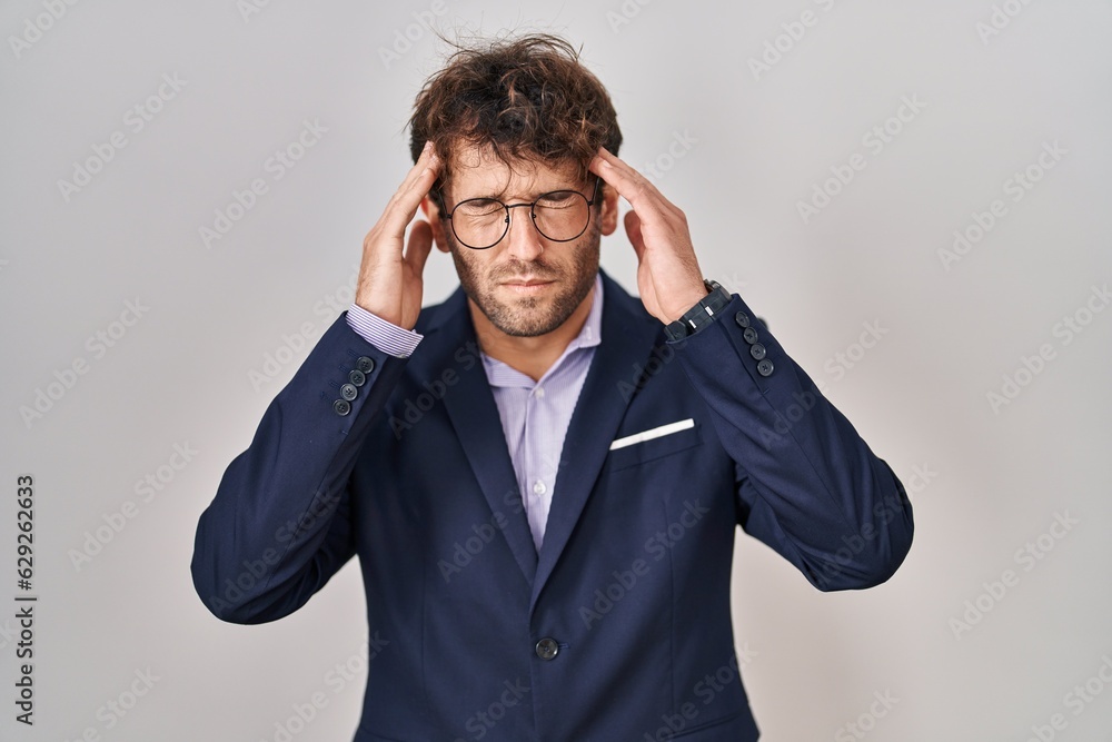 Hispanic business man wearing glasses with hand on head for pain in head because stress. suffering migraine. Hispanic business man wearing glasses with hand on head for pain in head because stress. suffering migraine.