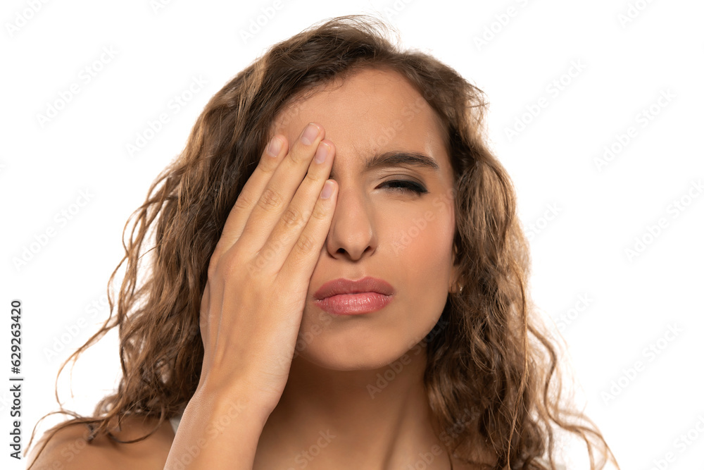 Young woman is covering his face with hand and checking his vision on a white background Young woman is covering his face with hand and checking his vision on a white background