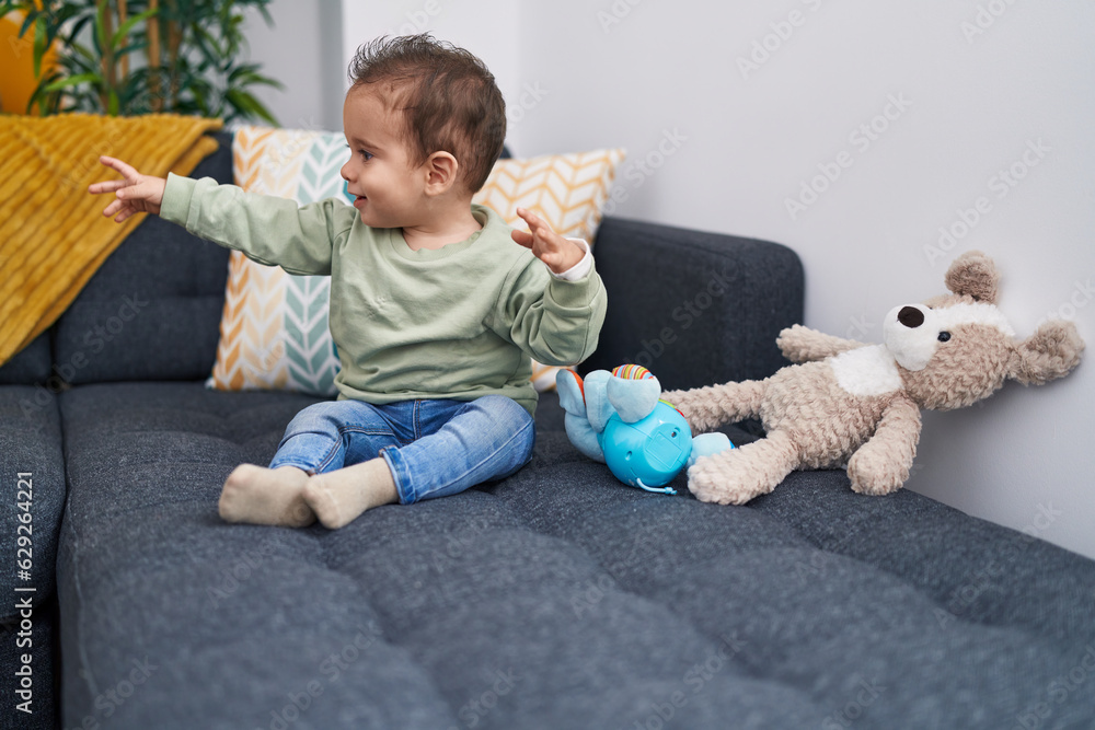 Naklejka premium Adorable hispanic boy smiling confident sitting on sofa at home