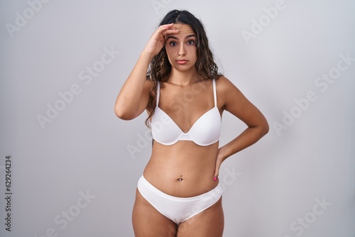 Young hispanic woman wearing white lingerie worried and stressed about a problem with hand on forehead, nervous and anxious for crisis © Krakenimages.com