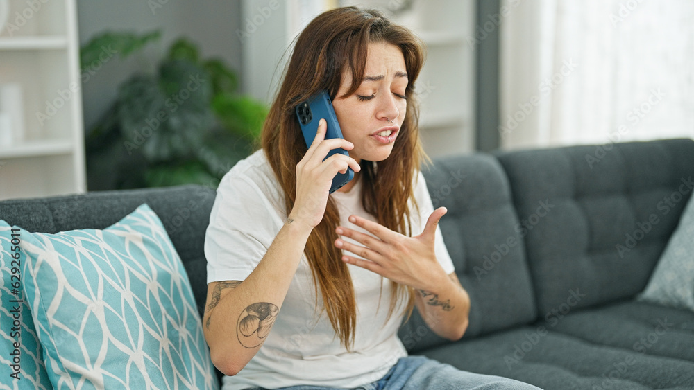 Young beautiful hispanic woman talking on the smartphone with serious expression at home Young beautiful hispanic woman talking on the smartphone with serious expression at home
