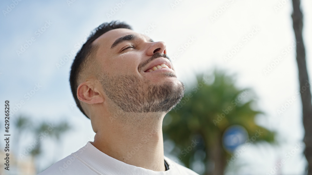 Young hispanic man breathing with closed eyes at street Young hispanic man breathing with closed eyes at street
