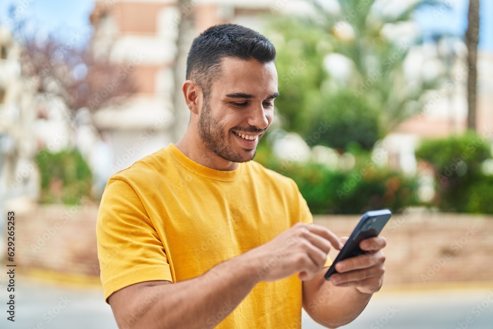 Young hispanic man smiling confident using smartphone at street Young hispanic man smiling confident using smartphone at street