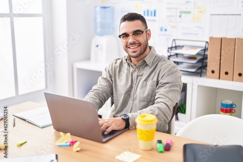 Young hispanic man business worker using laptop working at office