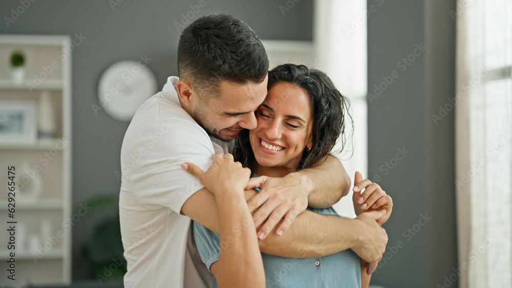 Man and woman couple hugging each other smiling at home Man and woman couple hugging each other smiling at home