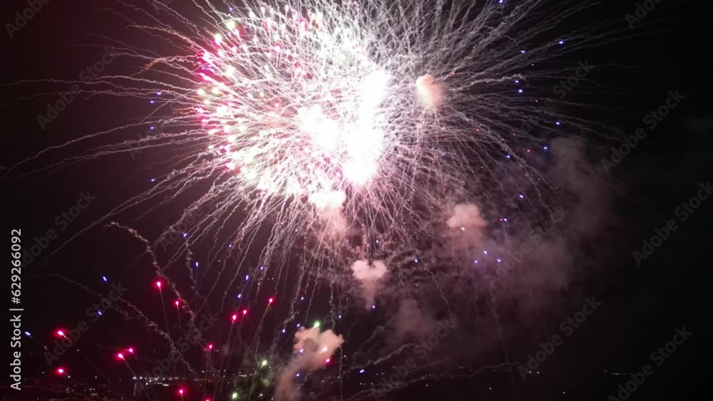 Aerial of the bright fireworks striking in the dark night sky Aerial of the bright fireworks striking in the dark night sky