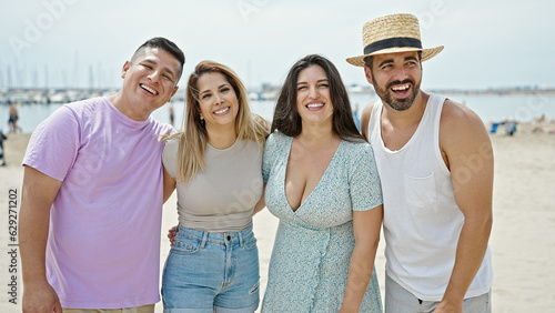 Group of people hugging each other smiling at beach