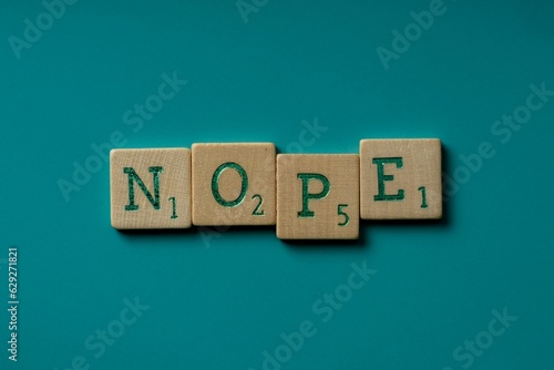 Obraz na płótnie Wooden letters spelling the word nope on a blue background