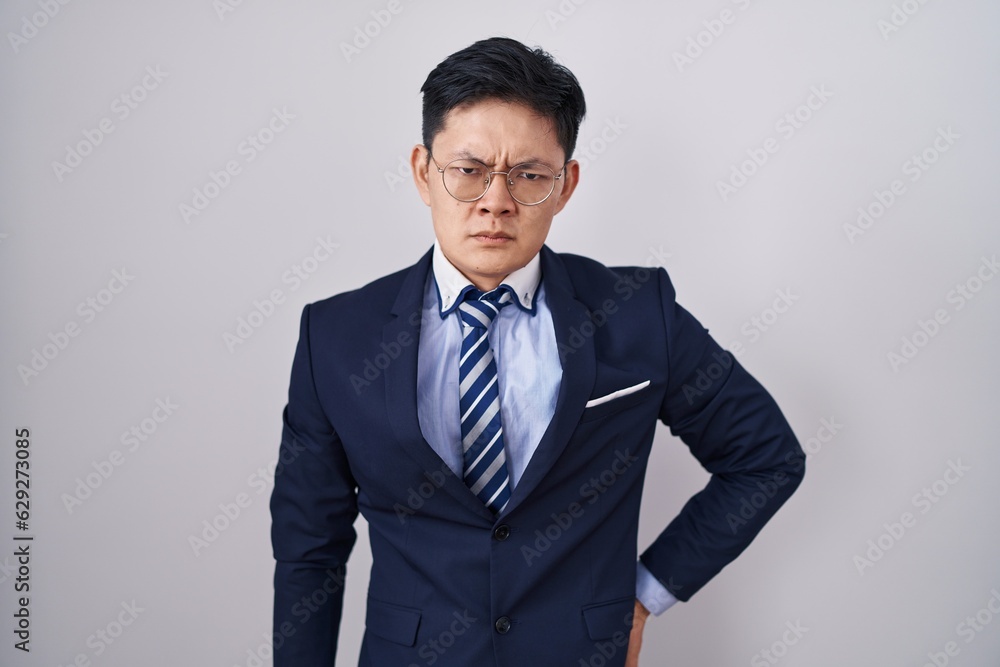 Young asian man wearing business suit and tie skeptic and nervous, frowning upset because of problem. negative person. Young asian man wearing business suit and tie skeptic and nervous, frowning upset because of problem. negative person.