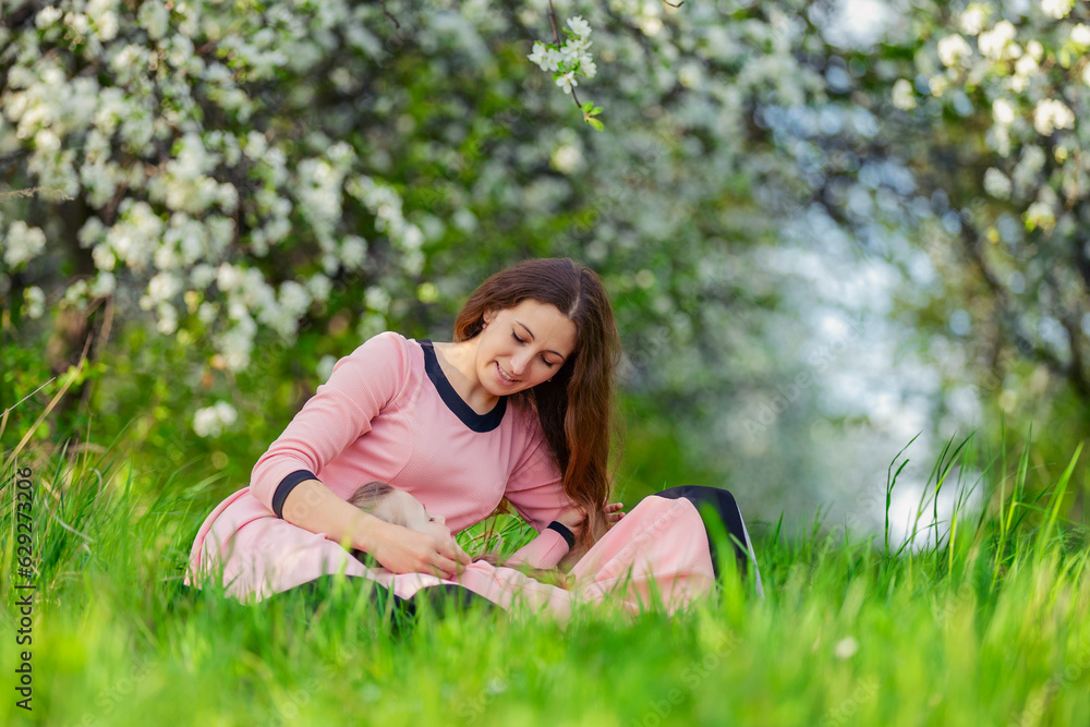 mother and daughter sit outdoors in a blooming garden mother and daughter sit outdoors in a blooming garden