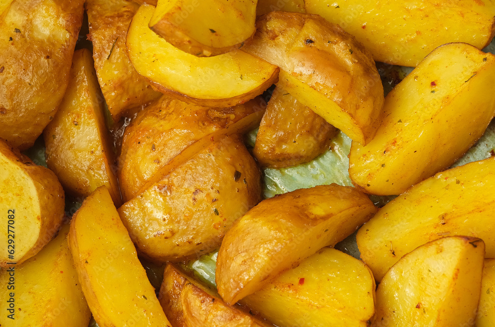 Background with slices of cooking fried potatoes in oil on a baking sheet Background with slices of cooking fried potatoes in oil on a baking sheet