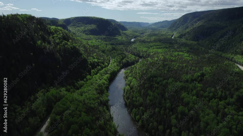 Drone view over a river flowing between forested hills Drone view over a river flowing between forested hills