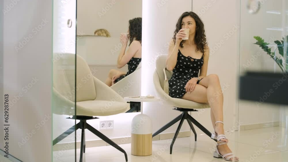 A girl sits in a shopping center and looks at the phone A girl sits in a shopping center and looks at the phone