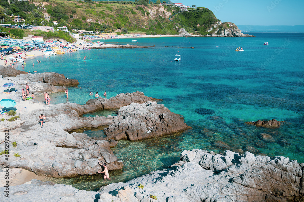Italy, July 2023: view of the spectacular and relaxing Grotticelle beach near Capo Vaticano in Calabria. You notice the rocks and the bathers having fun during their vacation