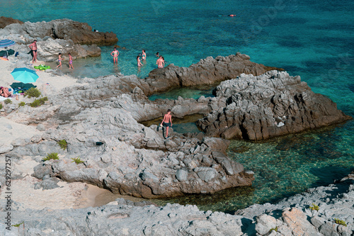 Italy, July 2023: view of the spectacular and relaxing Grotticelle beach near Capo Vaticano in Calabria. You notice the rocks and the bathers having fun during their vacation photo