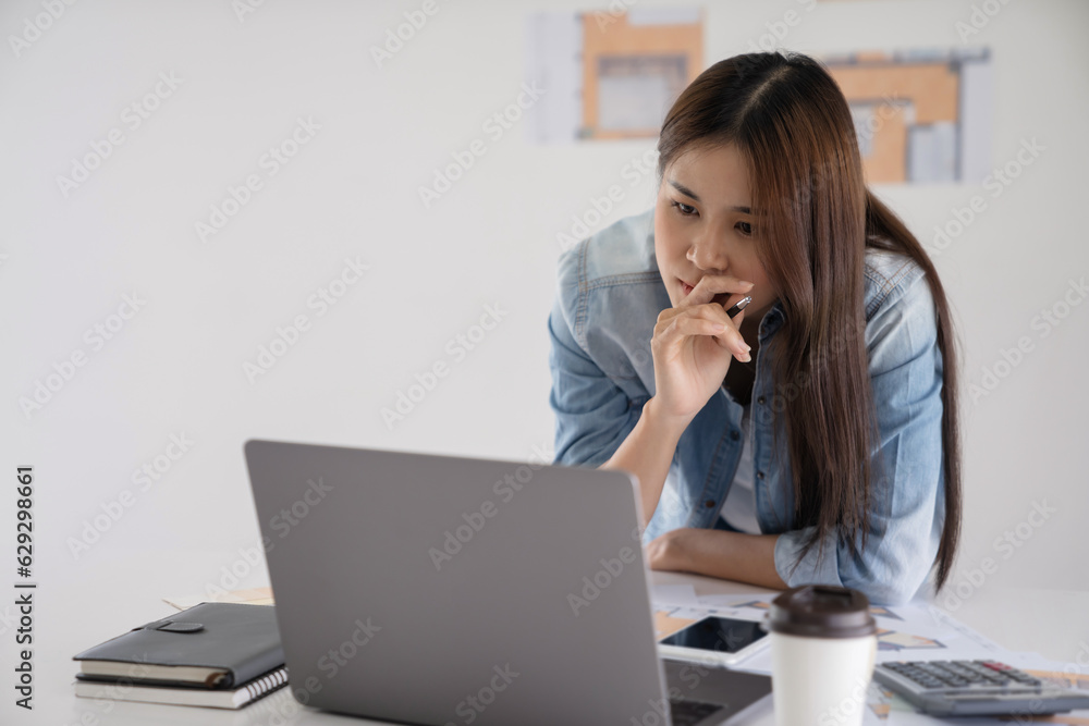Working woman Asian Architects designer using smartphone with laptop Working woman Asian Architects designer using smartphone with laptop