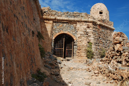 Entrance to the old fortress. Fortress of Granvousa in Greece on the island of Crete. Ancient ruins of a fortress. Bright, sunny day. Textured stonework.