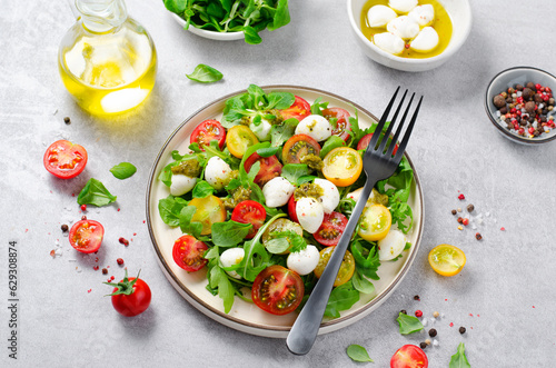 Caprese Salad with Cherry Tomatoes and Pesto Sauce over Bright Background
