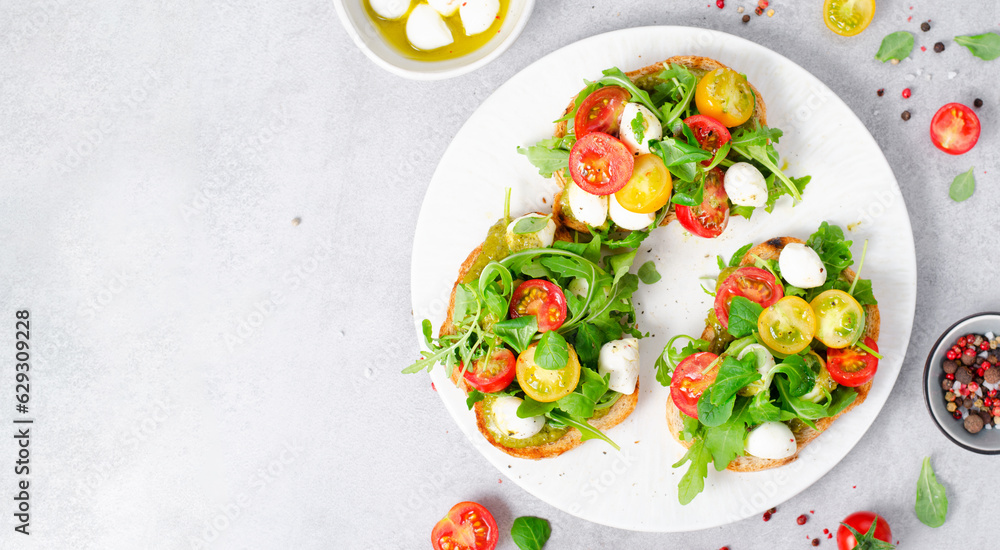 Bruschetta with Cherry Tomatoes, Mini Mozzarella Cheese and Pesto Sauce, Caprese Toasts Bruschetta with Cherry Tomatoes, Mini Mozzarella Cheese and Pesto Sauce, Caprese Toasts