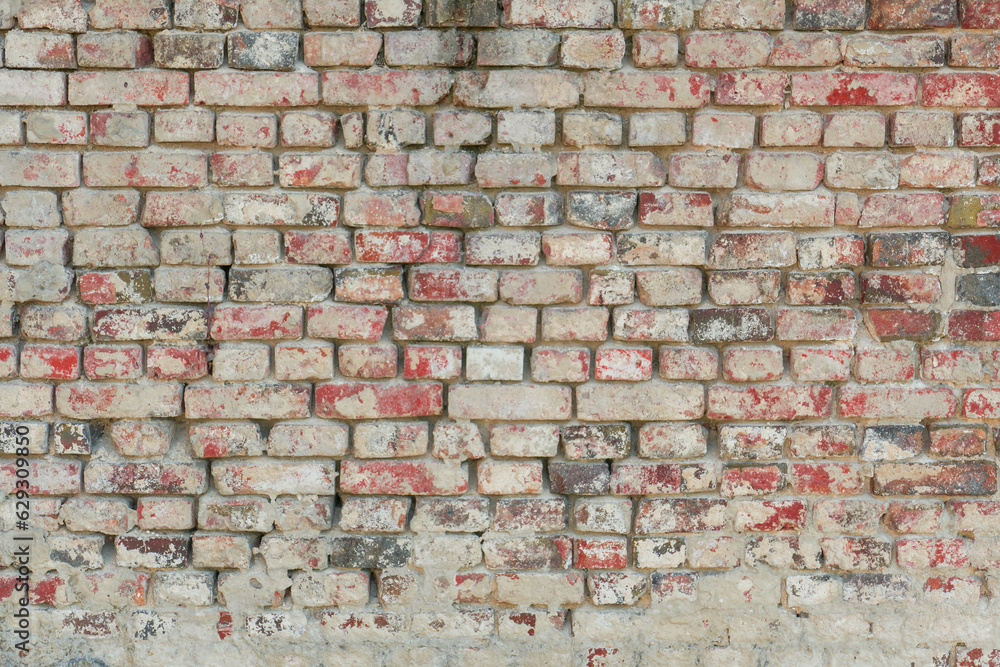 Obraz premium Zdjęcie przedstawiające teksturę utworzoną przez cegły ułożone w równych rzędach w murze. Cegły częściowo pokryte są zaprawą murarską. Stanowią one element starej budowli.