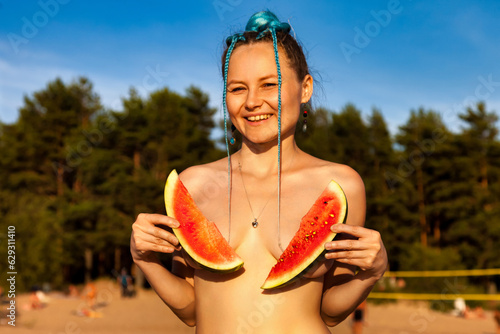 Smiling naturist lady posing close up watermelon naked on beach, looking at camera. Perfect nude nudist woman, no clothes. Nudism naturism lifestyle concept, clothing optional. Copy ad text space